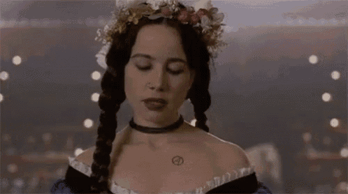a woman wearing a choker and a crown of flowers on her head .