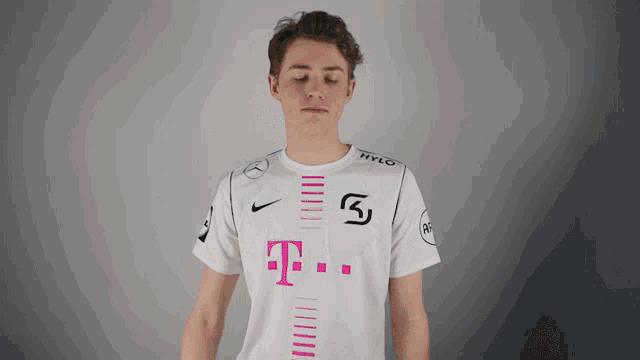 a man is wearing a white shirt with a pink t on it