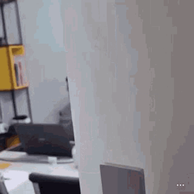 a person is sitting at a desk in front of a computer monitor .