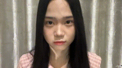 a young woman with long black hair is making a funny face .