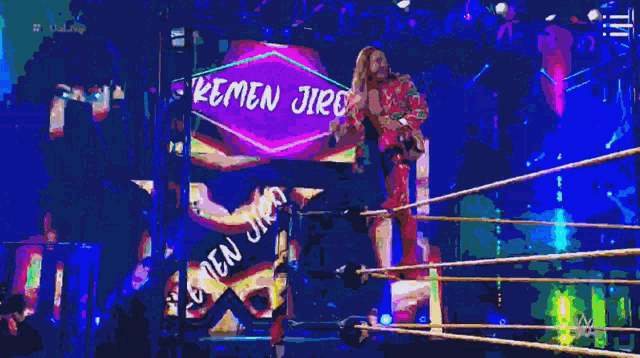 a man in a wrestling ring with a sign that says emen jire