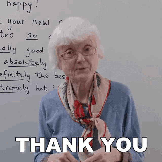 an elderly woman is standing in front of a white board and says thank you