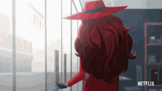 a woman in a red hat is standing in front of a glass door with a netflix logo in the corner