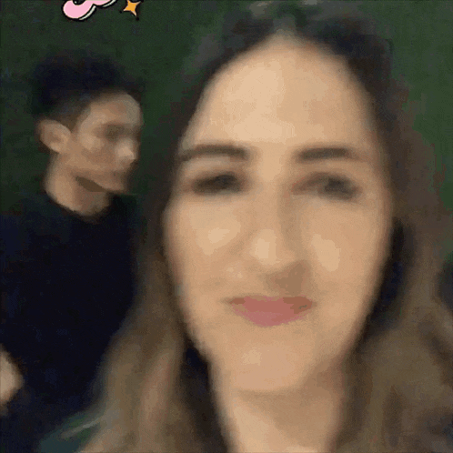 a blurry picture of a woman 's face with a man in the background