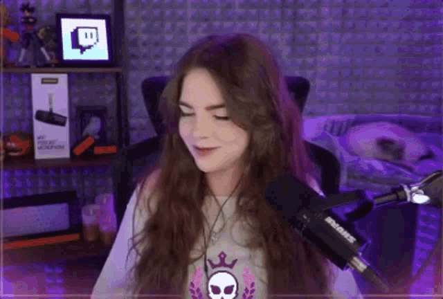 a woman is sitting in front of a shure microphone in a purple room .