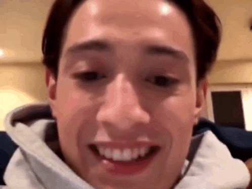 a close up of a man 's face with his mouth open and his teeth visible .