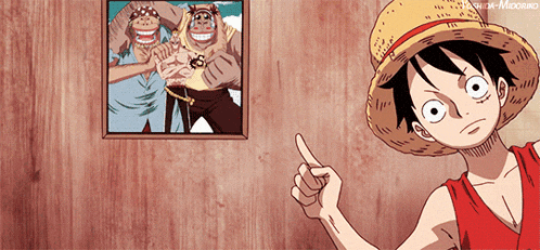 monkey d luffy is pointing at a picture on a wooden wall