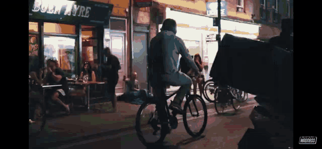 a man riding a bike down a street in front of a store called boln ayre
