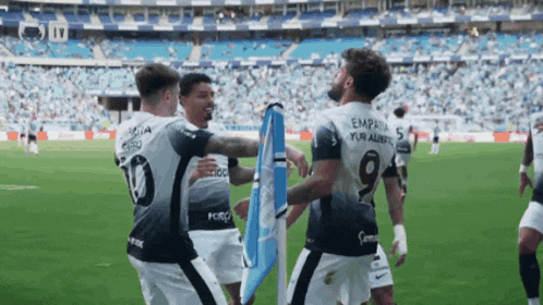 a soccer player with the number 19 on his back is hugging another player