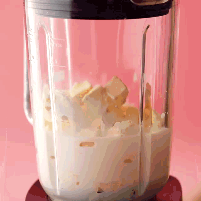 a blender filled with whipped cream and ice cubes