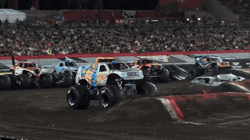 a monster truck is jumping in the air in front of a coca cola billboard