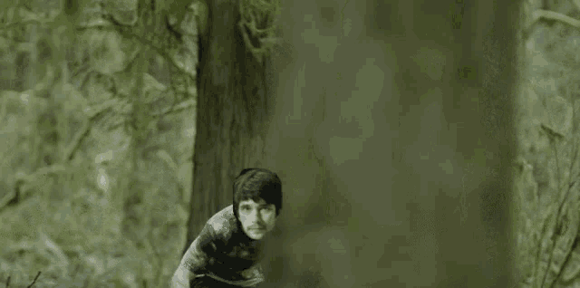 a man riding a bike in the woods with a cartoon face on his face