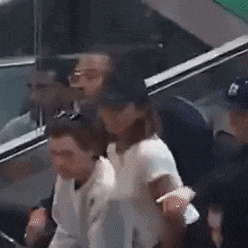 a group of people are standing in front of a car and kissing .