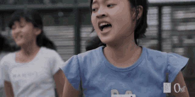 a girl wearing a blue shirt that says one