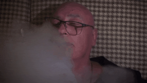 smoke is coming out of a dark room with a checkered pattern on the wall .