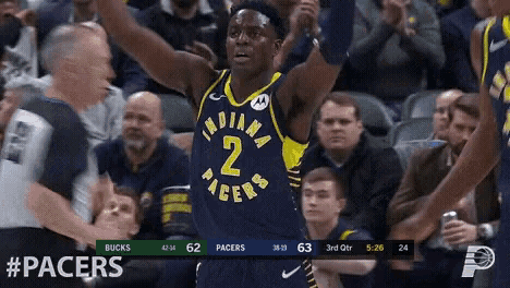 a basketball player for the indiana pacers holds his arms in the air