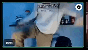a man in a white shirt is standing in front of a blue wall and a button that says puss .