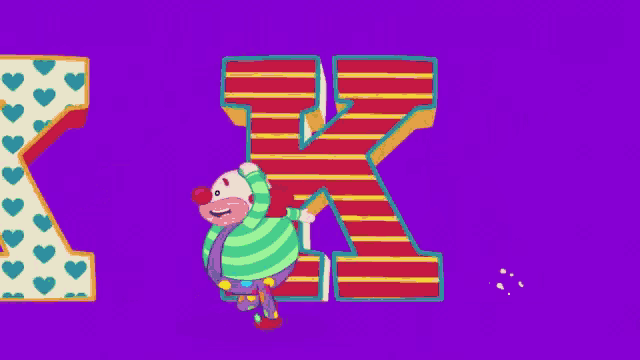 a clown is standing next to the letter k with hearts on it