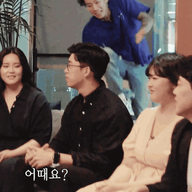 a group of people are sitting in a room and one of them is asking a question in korean
