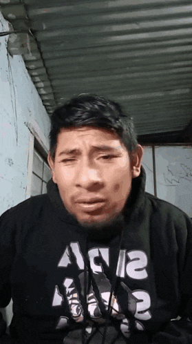 a man wearing a black hoodie with the letters a and a on it