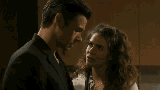 a man and a woman are looking at each other in front of a picture