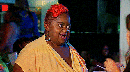a woman with red hair is wearing a yellow shirt