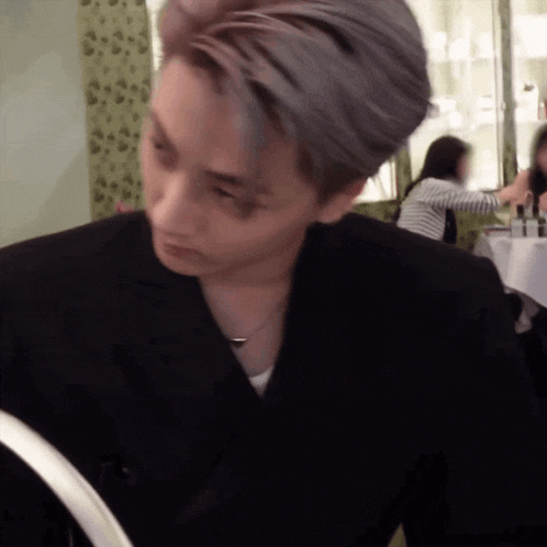 a man in a black suit is looking at something