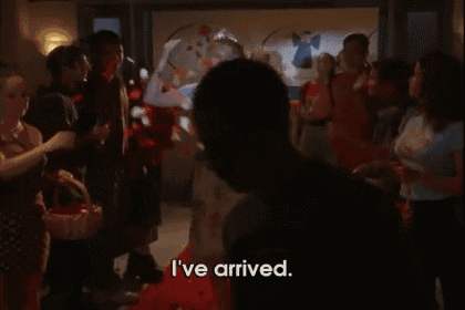a woman wearing a tiara says i 've arrived while standing on a red carpet