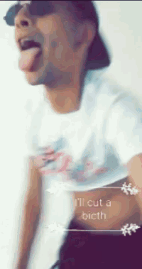 a man wearing sunglasses and a white shirt is sticking his tongue out