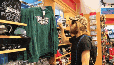 a man looks at a green eagles football sweatshirt