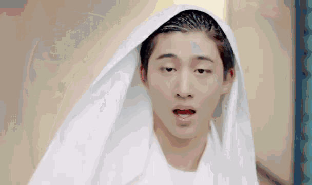 a young man wearing a white towel on his head .
