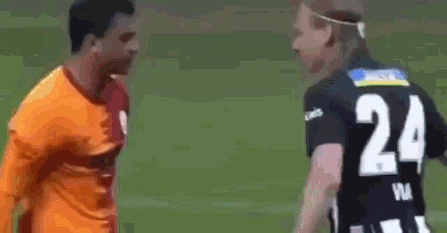 a soccer player with the number 24 on his back is talking to another player