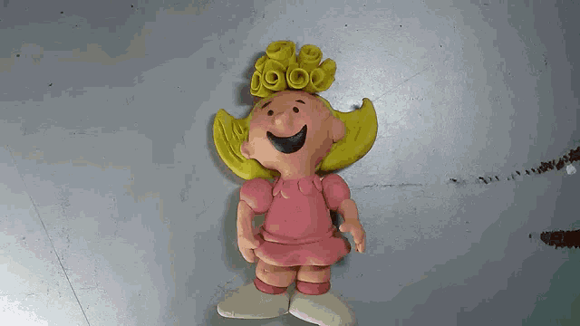 a clay figurine of a girl with yellow hair