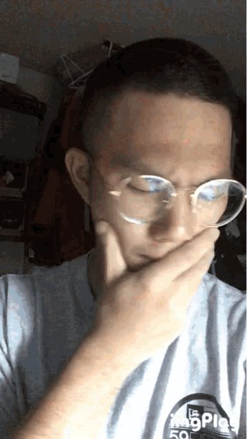 a man wearing glasses and a t-shirt that says ' breaking bad ' on it