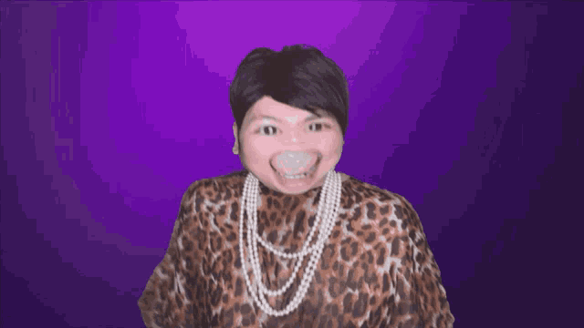 a woman wearing a leopard print shirt and pearls is making a face