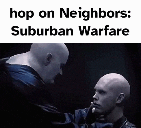 two bald men are standing next to each other in a dark room and looking at each other .