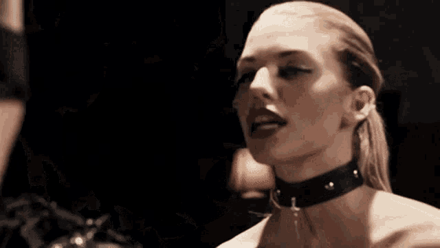 a close up of a woman wearing a choker .