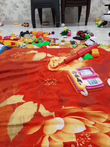 a bunch of toys are laying on a bed including a phone