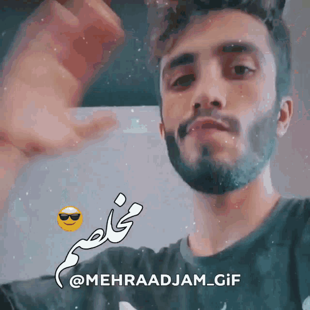 a man with a beard is holding up a card with the name mehraadjam_gif written on it