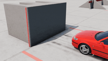 a red car is parked in front of a concrete wall