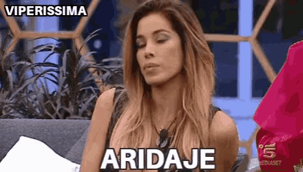 a woman is sitting on a couch with her eyes closed and the word aridaje written on her face