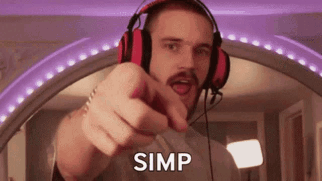 a man wearing headphones and a mustache is pointing at the camera and says simp .