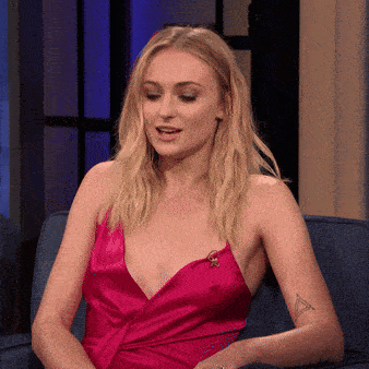 a woman in a pink dress is sitting on a blue couch