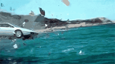 a car is crashing into the ocean and breaking through the glass .