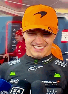 a man wearing an orange hat is smiling and holding a microphone .