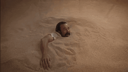 a person is laying in a pile of sand