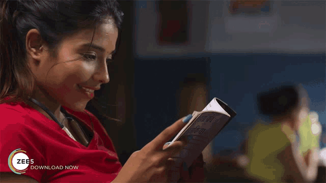 a woman in a red shirt is reading a book with the words zee5 download now on the bottom right