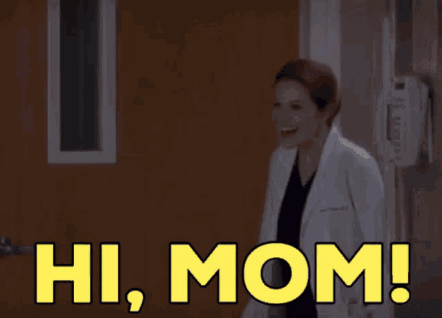 a woman in a lab coat is standing in front of a door that says hi mom