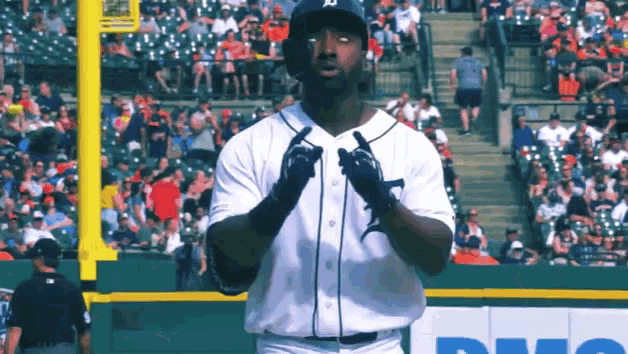 a baseball player wearing a detroit jersey stands on the field
