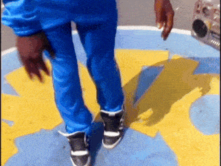 a person wearing blue pants and black and white shoes is dancing
